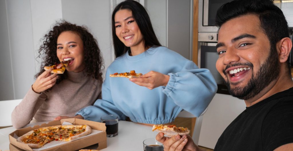 amigos comen pizza
